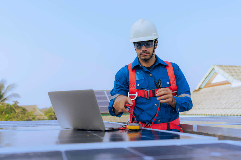 solar maintenance technician with a laptop performing diagnostics