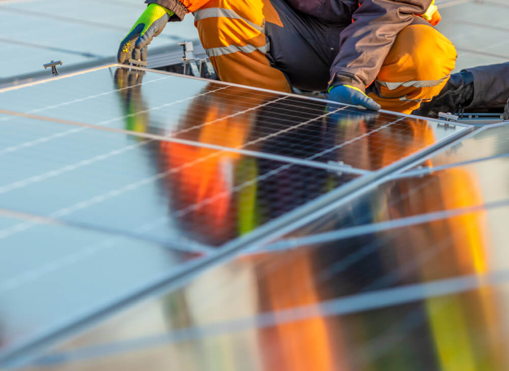 PV technician installing a solar panel for an outdoor solar farm