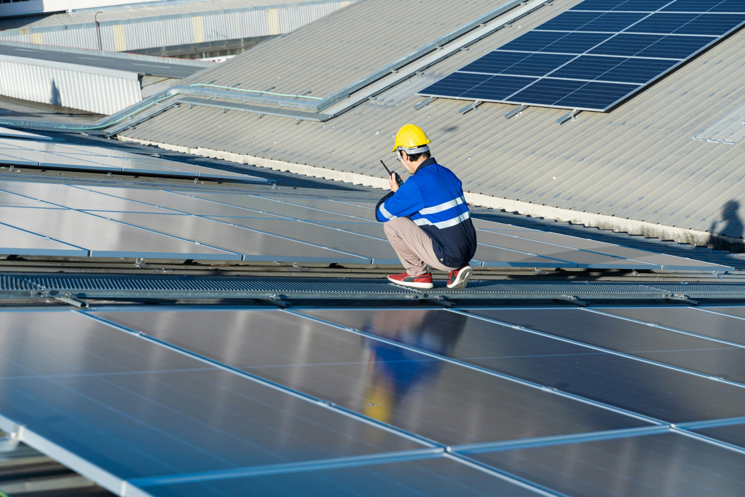A technician inspecting solar panels on a rooftop, emphasizing the importance of maintenance and monitoring for optimal performance and managing depreciation.
