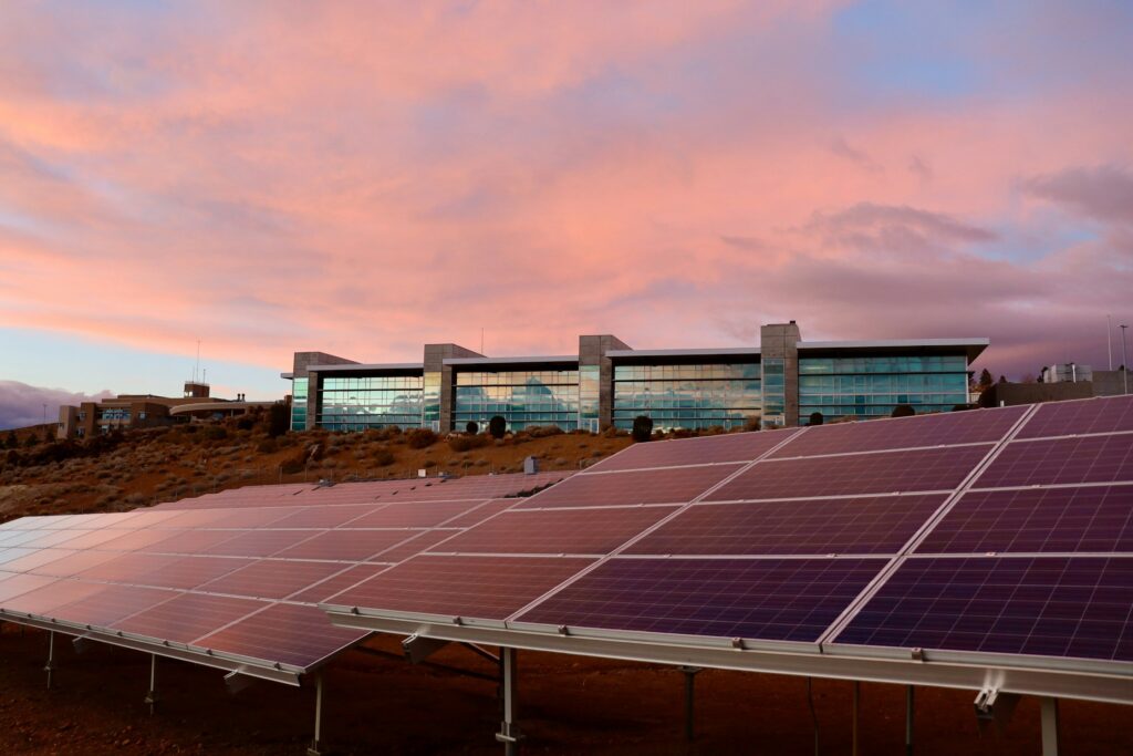 Solar panels installed in front of a modern commercial building in the Midwest at sunset, illustrating the corporate responsibility of solar energy integration.